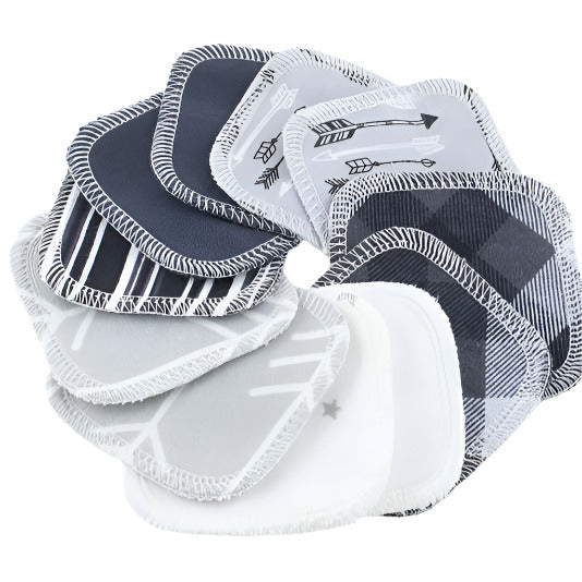 Close-up of white reusable facial rounds stacked, showing soft terry cloth texture and neatly sewn edges on monochrome