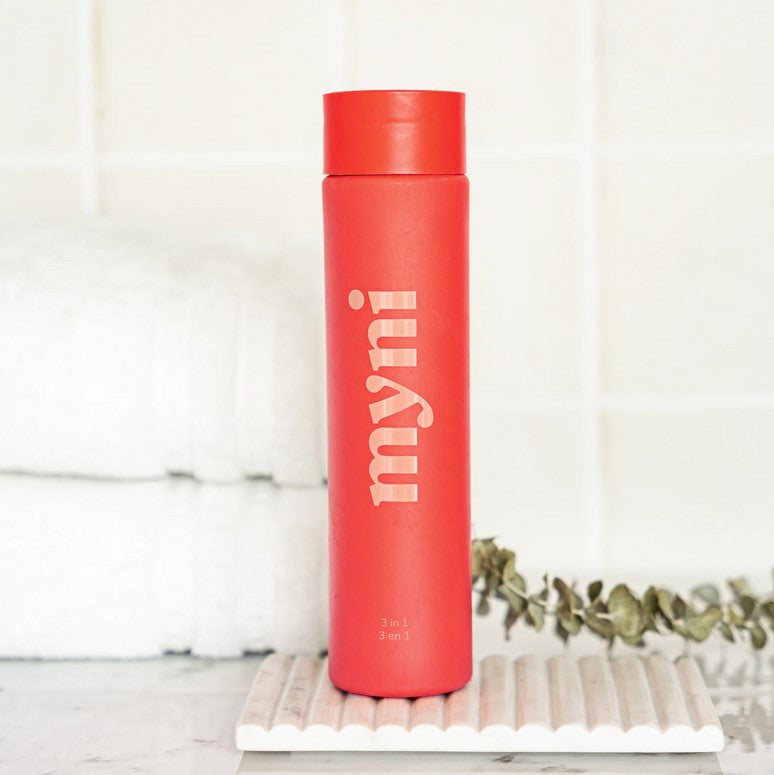 Close-up of Myni 3-in-1 Starter Set bottle showing textured label and gentle scent notes on the side panel