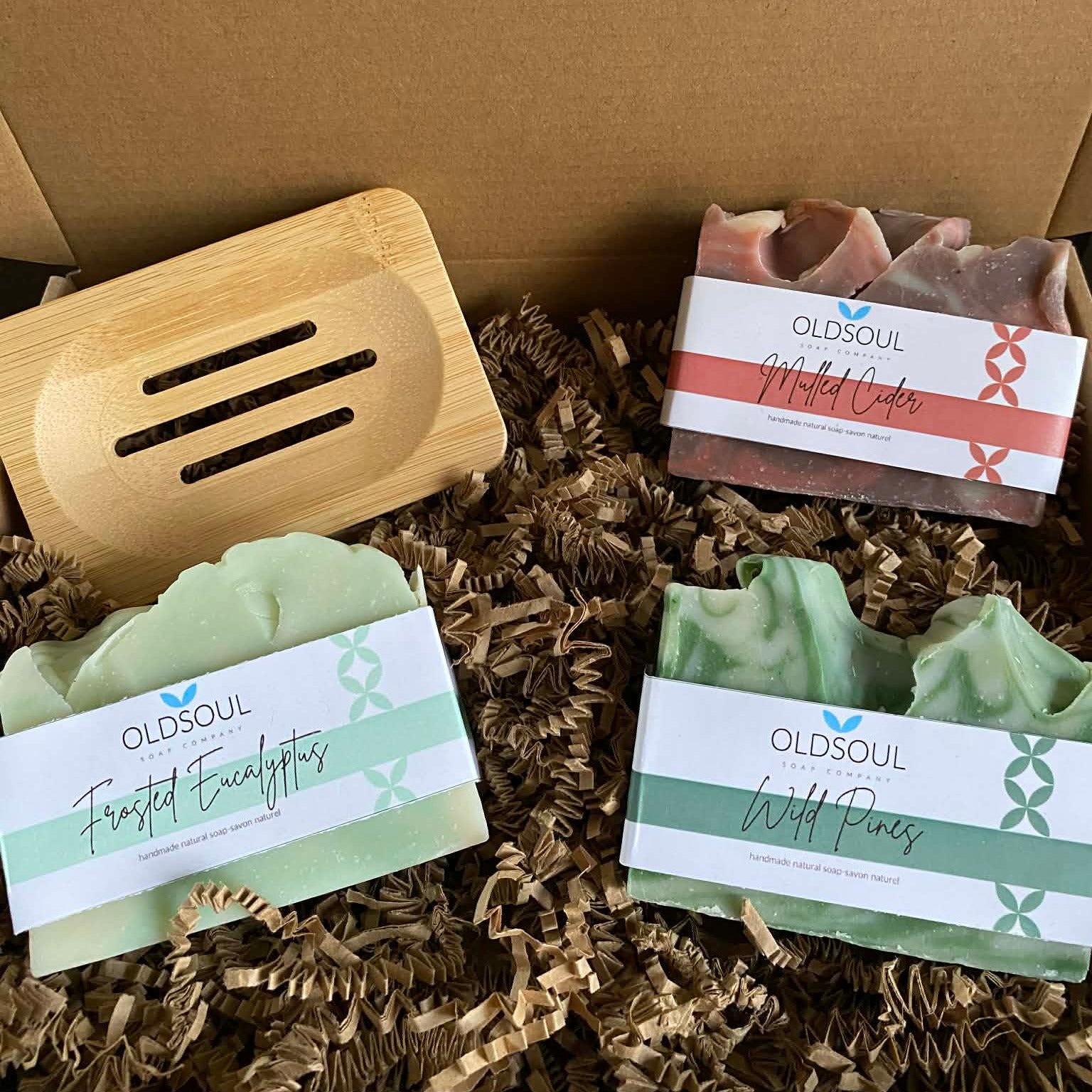 Holiday Soap Gift Set featuring Old Soul Soap Company’s Mulled Cider, Frosted Eucalyptus, and Wild Pines artisan soaps with a bamboo soap dish arranged in eco-friendly gift box.