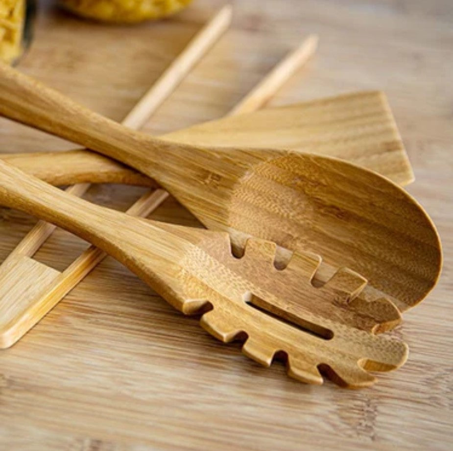 Close-up of the smooth bamboo handle with engraved Ola logo and textured surface detail on utensil end