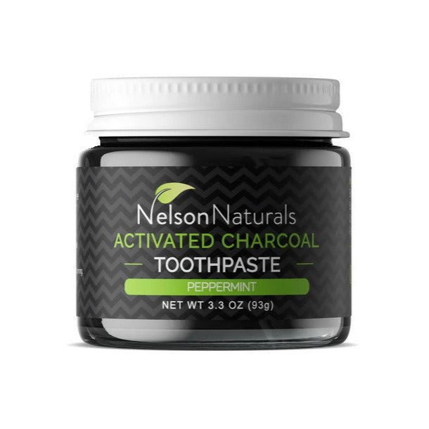 Nelson Naturals activated charcoal toothpaste in a clear glass jar with black lid, peppermint-flavored, textured black paste