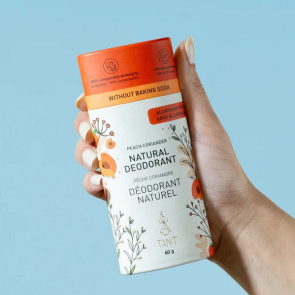 Tanit Botanics Peach Coriander stick deodorant in compostable packaging with tan-colored solid stick and lemon scent details