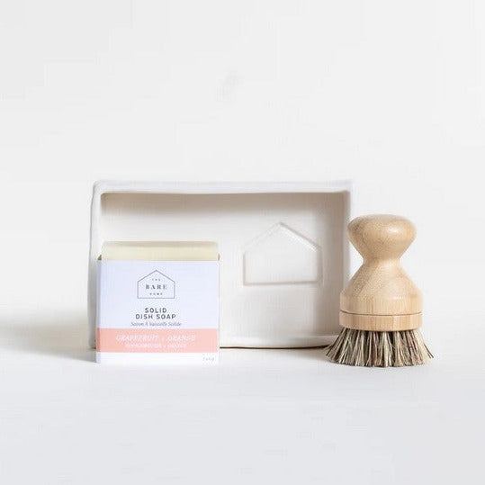 Close-up of the white ceramic soap tray’s textured underside and subtle glaze details from a bottom angle.