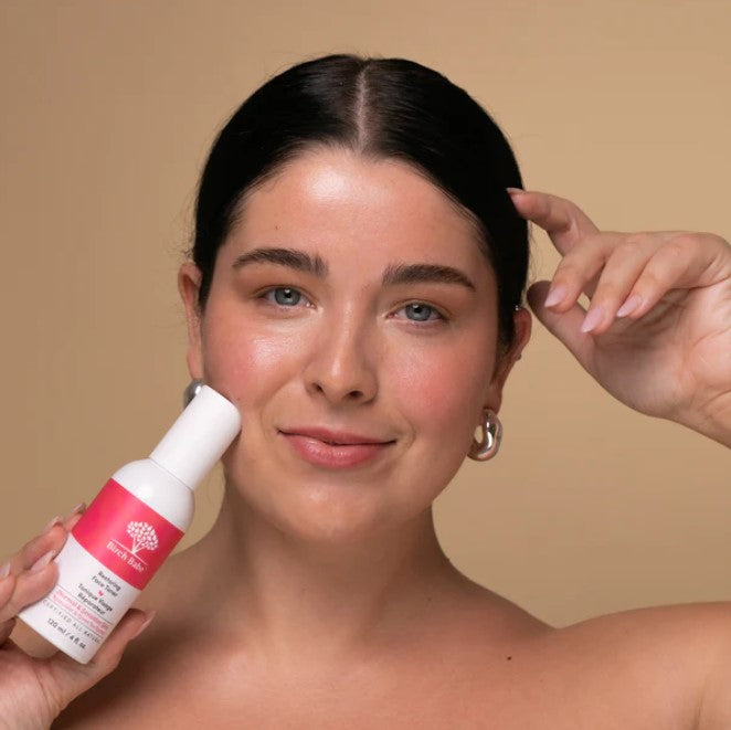Close-up of the Restoring Face Toner’s textured glass bottle with a silver pump and botanical label detail from the top angle