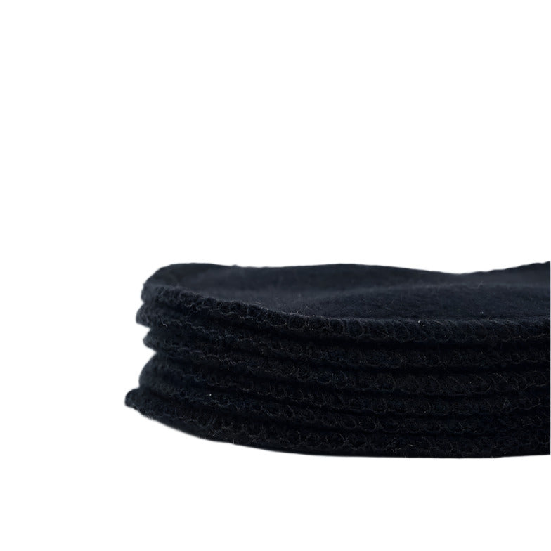 Close-up of black hemp and bamboo fibers highlighting the textured surface of facial rounds for gentle, exfoliating skincare