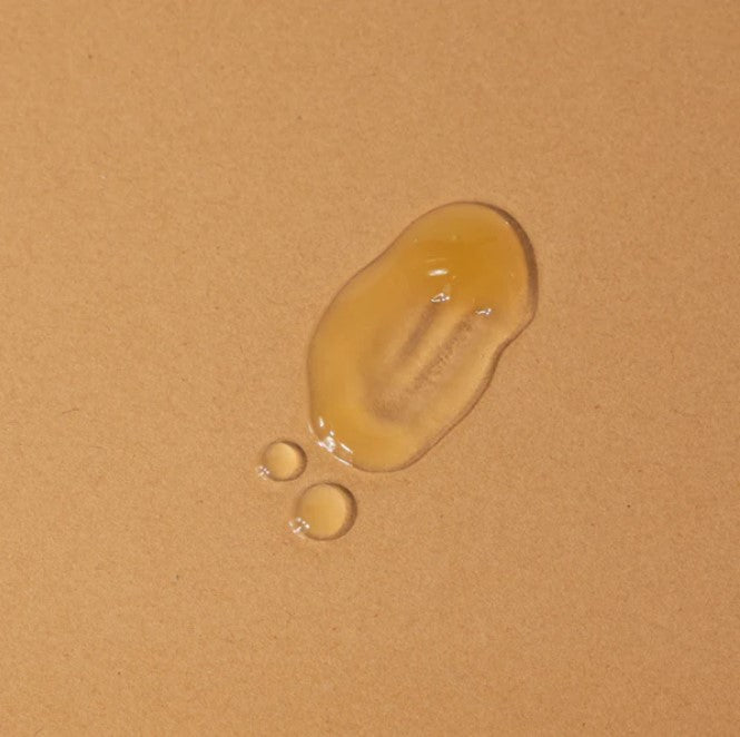 Close-up of the Golden Hour Brightening Serum bottle with fresh floral scent and textured dropper cap, highlighting elegant