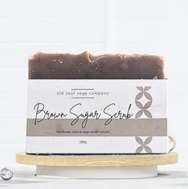 Close-up of three colorful, textured soap bars with embossed floral patterns, arranged in a clear gift box display