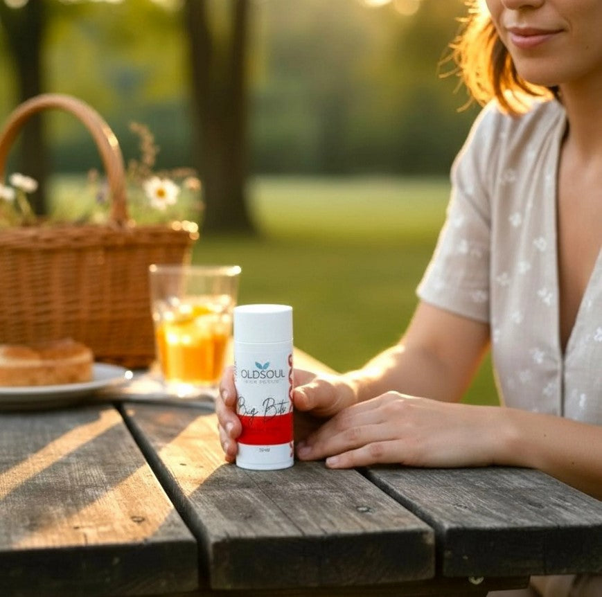 Woman holding Bug Bite Balm natural insect bite soothing stick outdoors at picnic table during summer camping and cottage season in Canada