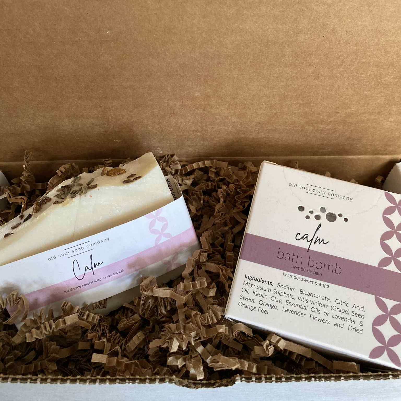 Calm Soap and Bath Bomb Gift Set with two white rectangular soap bars embossed with "calm," and a round purple bath bomb