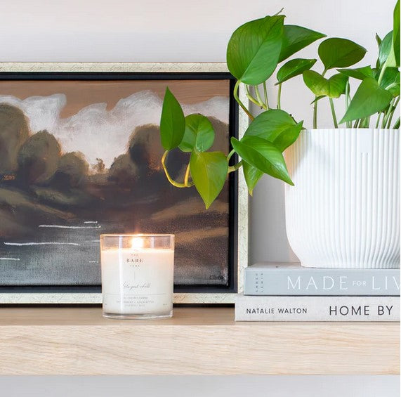 Close-up of the candle’s frosted glass jar showing the textured finish and subtle amber hue, highlighting the material