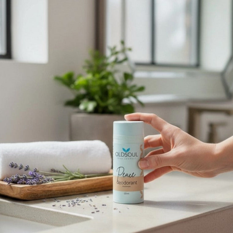 Hand holding Peace Natural Deodorant by The Old Soul Soap Company, a Canadian-made aluminum-free deodorant scented with lavender, rosemary, and peppermint, styled in a calm bathroom setting.
