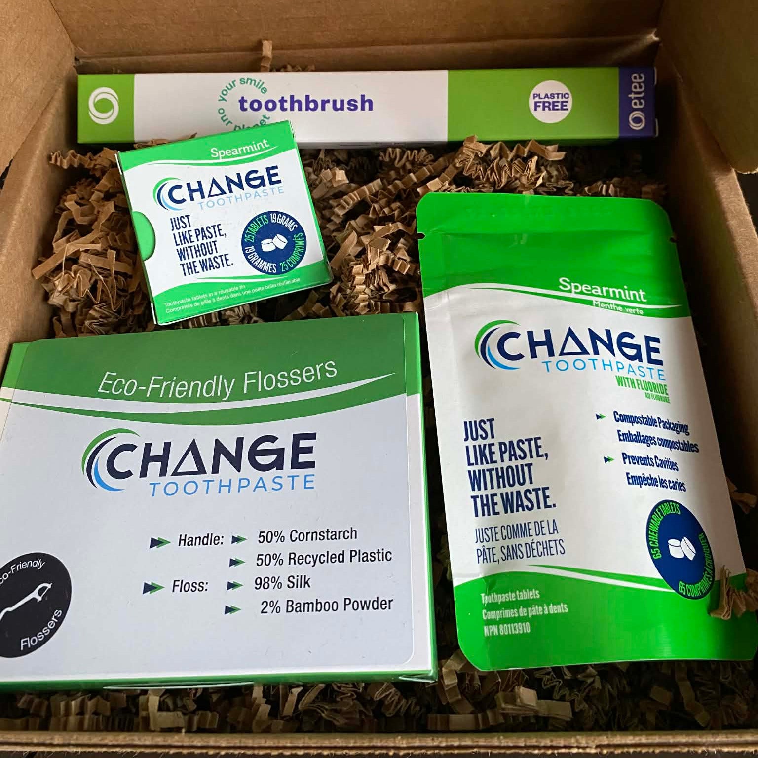 Eco-friendly Change Toothpaste starter kit featuring spearmint toothpaste tablets with fluoride, sustainable flossers, plastic-free etee toothbrush, and compostable packaging in kraft box.