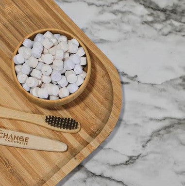 Close-up of spearmint-flavored tablet texture featuring embossed branding and vibrant green specks on transparent packaging.