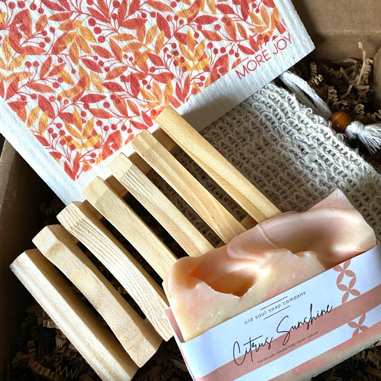 Close-up of the open Citrus Sunshine Gift Box revealing vibrant orange tissue paper and hand-tied yellow ribbon bow on the