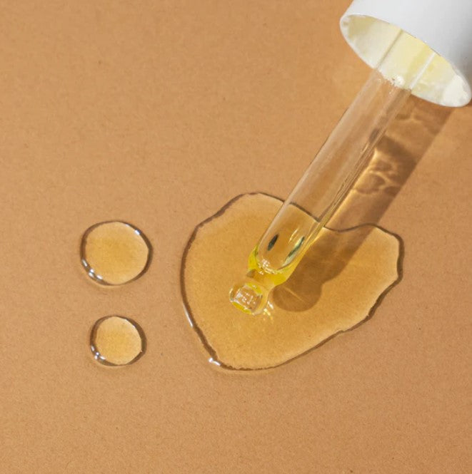 Close-up of the Double Duty Face Oil’s transparent glass bottle with dropper, highlighting calming lavender scent and silky