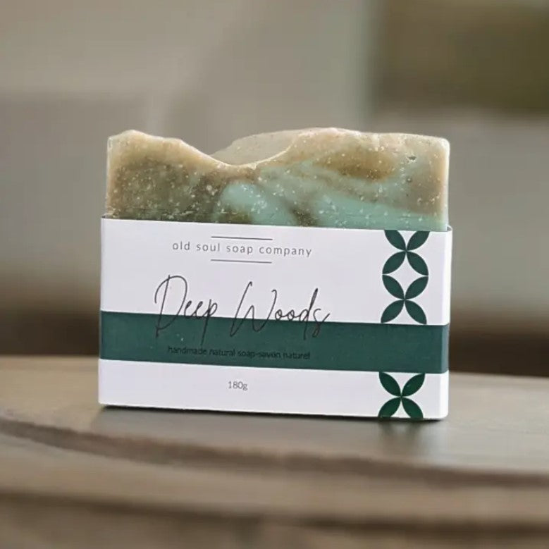 Earthy 180 g handcrafted bar soap with Deep Woods on the label sits on a counter