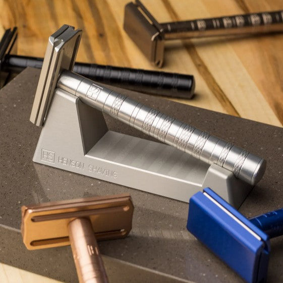 Close-up of the Henson Razor Stand’s textured matte black silicone grip and sleek chrome base from a top-down perspective.