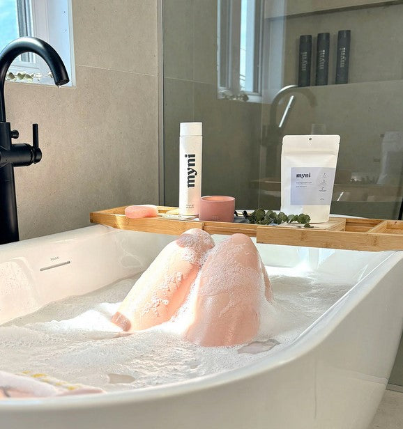 Close-up of Myni Bubble Bath Tablets container displaying textured label and colorful packaging design on a white background