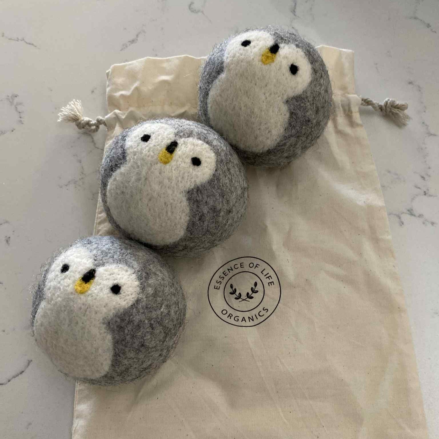 Close-up of penguin wool dryer balls demonstrating soft, textured surface with visible fibers and natural color variations