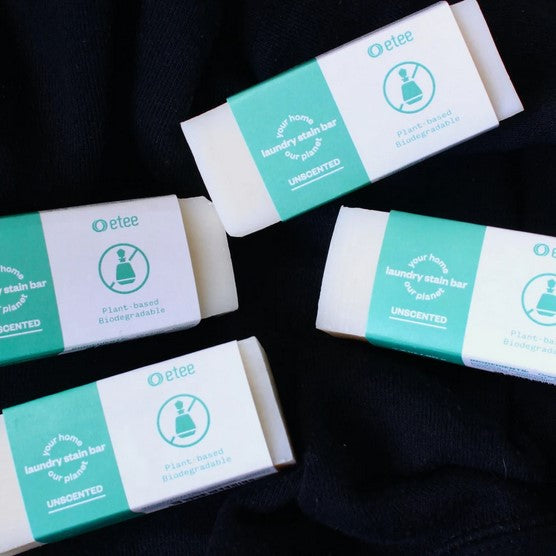 Close-up of the Etee Laundry Stain Stick's textured white plastic twist-up base with purple branding and tip detail