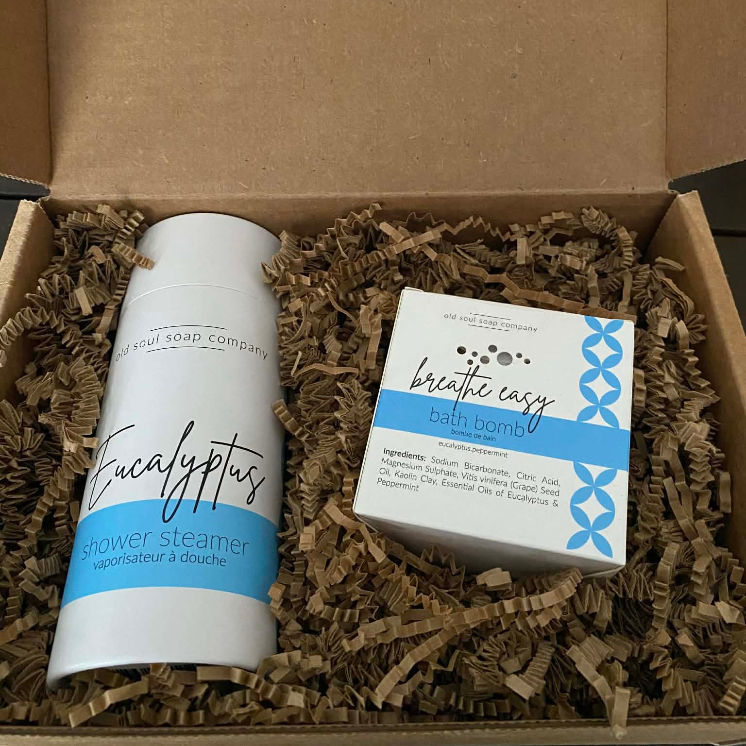 Eucalyptus Breathe Easy Gift Set with eucalyptus shower steamers and Breathe Easy bath bomb from Old Soul Soap Company displayed in eco-friendly gift box with kraft paper filling