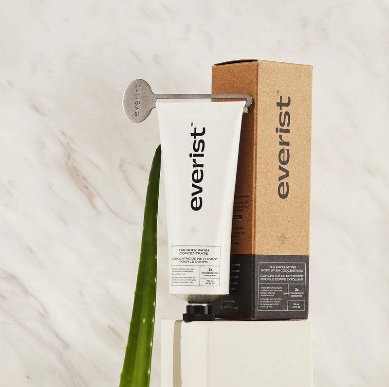 Close-up of the Everist Exfoliating Body Wash concentrate bottle’s textured amber plastic cap and clear label details.