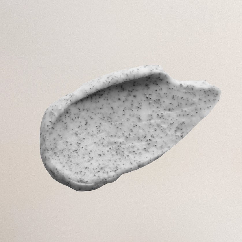 Close-up of the Everist Exfoliating Body Wash bottle neck featuring textured, peach-colored gel and clear cap with minimal