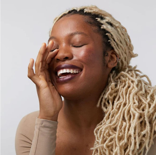 Close-up of the Fireside Temptation Lip & Cheek Tint tube’s deep burgundy matte finish, highlighting minimalist branding and
