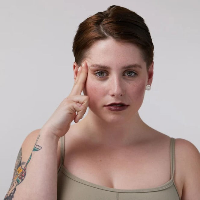 Close-up of the Fireside Temptation Lip & Cheek Tint tube displaying the deep burgundy matte label and sleek packaging