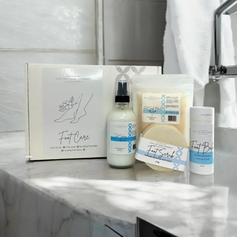 Old Soul Soap Company foot care gift set with four herbal-infused creams in white and teal tubes, textured labels, and kraft