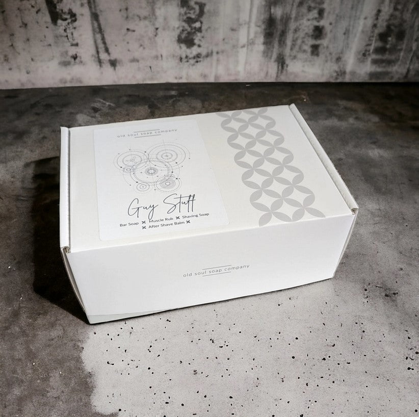 Close-up of the Guy Stuff Gift Box lid revealing textured black matte finish and bold embossed logo detail.