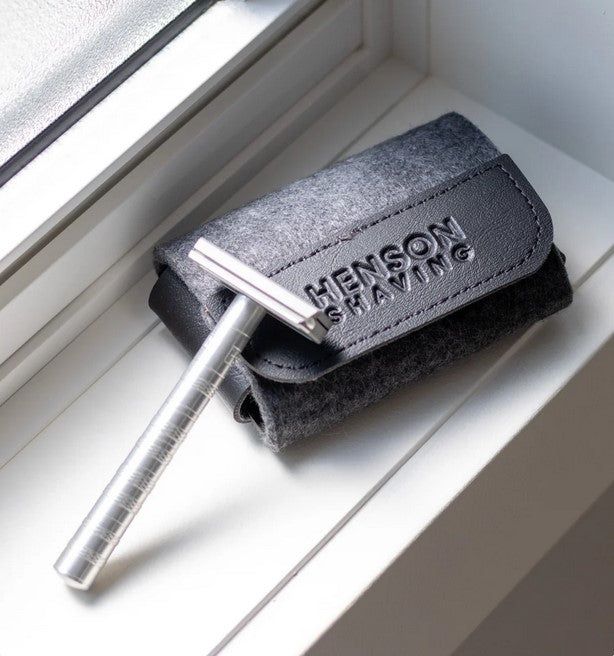 Henson Razor Travel Case holding a silver Henson safety razor displayed on a windowsill