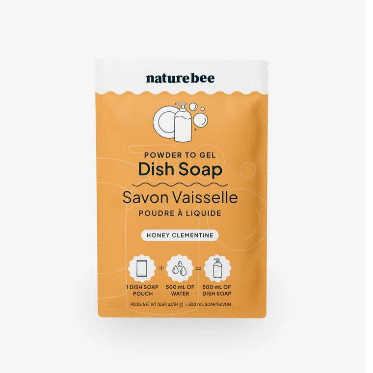 Nature Bee Clean powder to gel dish soap in yellow-orange honey clementine scent, white powder, mixing bowl, and measuring