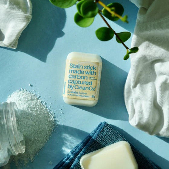 CleanO2 Sustain Eraser stain stick on laundry counter with detergent and towels – natural Canadian laundry pre-treatment for grease and oil stains