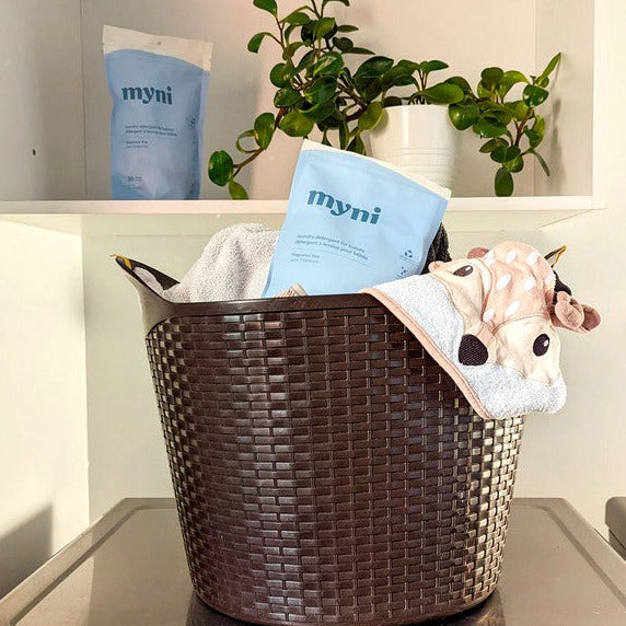 Close-up of Myni Baby Laundry Detergent bottle label highlighting gentle, plant-based ingredients and eco-friendly symbols