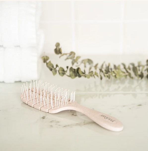 Close-up of the Myni Wheat Straw Hair Brush’s textured bristle surface and eco-friendly wooden base from a top-down angle