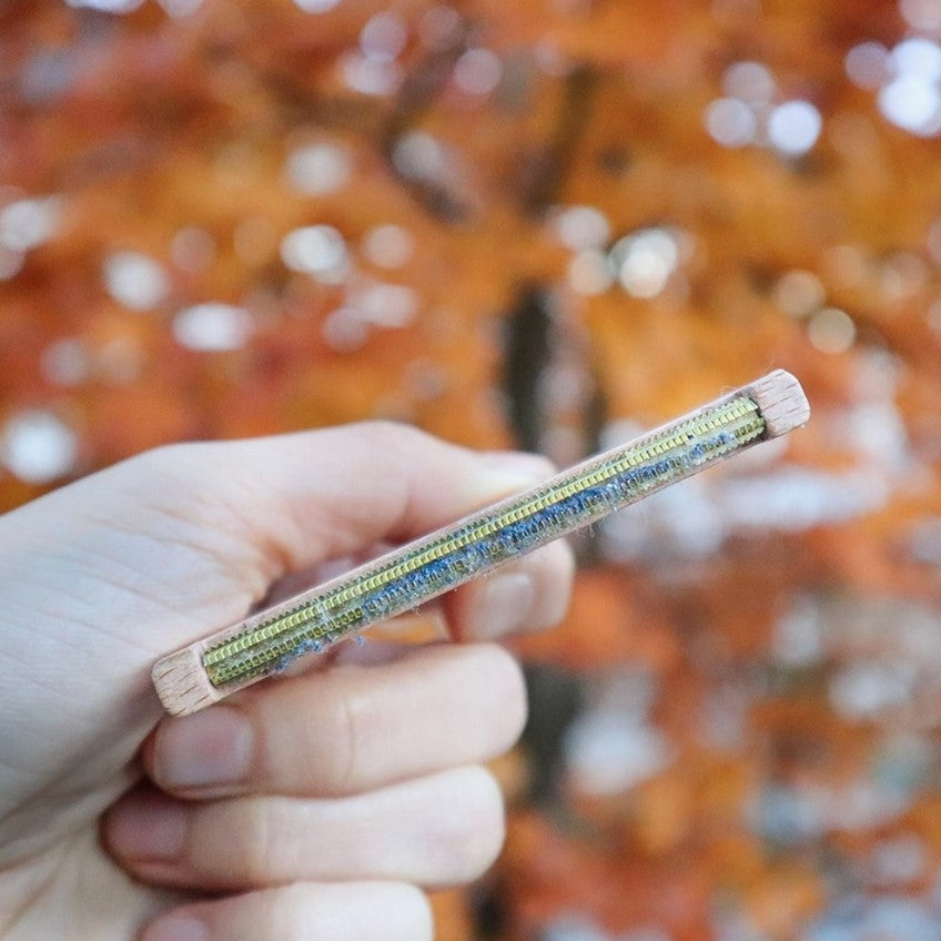 Close-up of the Plantish Wooden Lint Remover's textured rubber cleaning surface with visible wood grain handle detail
