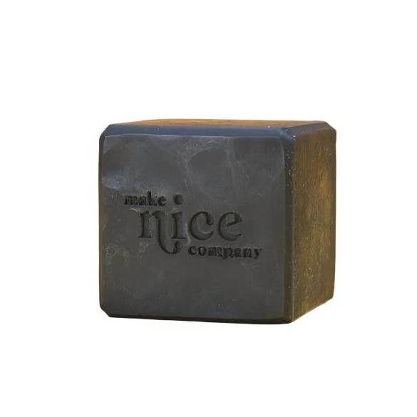 Close-up of the charcoal solid dish soap bar’s textured surface with visible natural ash particles and rougher edges