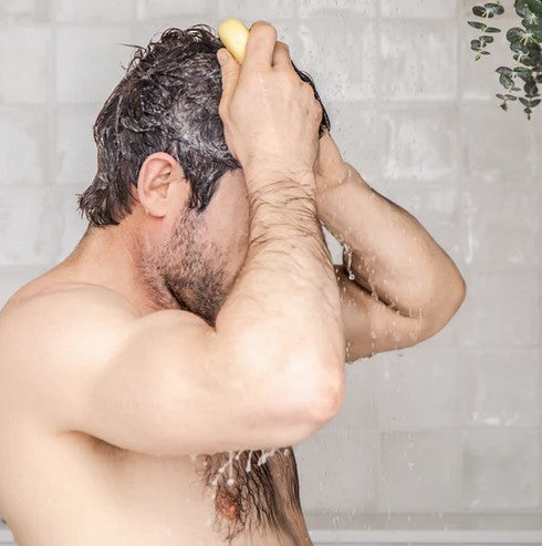 Close-up of the lavender and sage-scented shampoo bar lettering embossed on the textured, natural soap surface