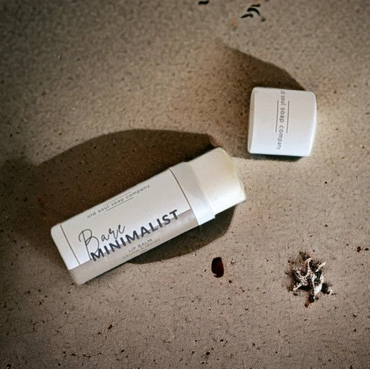 Close-up of the minimalist lip balm container’s smooth matte finish and subtle branding embossed on the lid