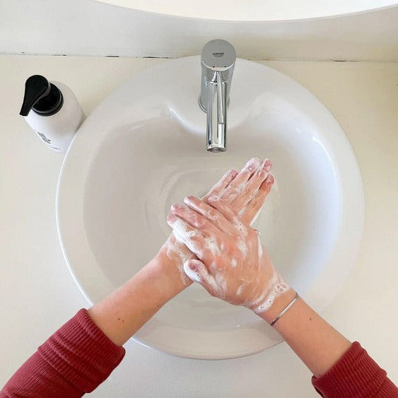 Close-up of Myni Liquid Hand Soap Starter Set’s clear gel texture and vibrant label on angled packaging, highlighting