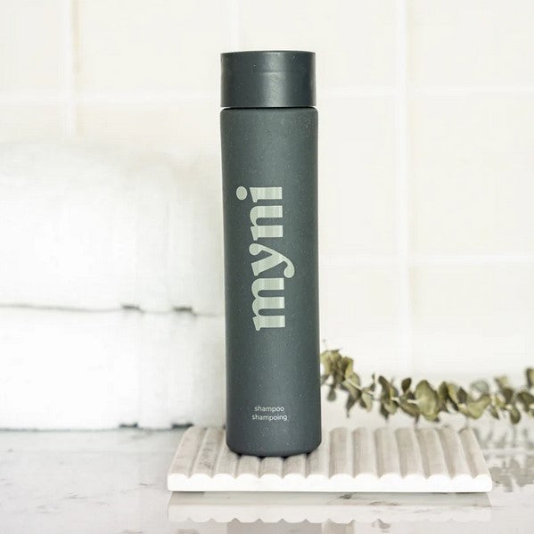 Close-up of Myni Shampoo Starter Set bottle cap with textured grip and eco-friendly label detail on a white background.