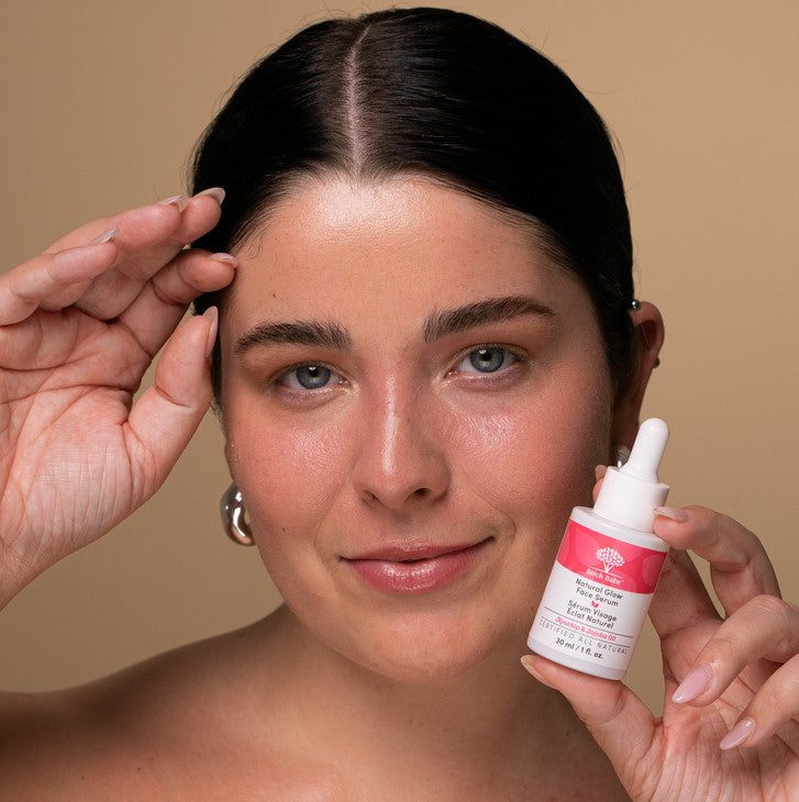 Close-up of the Natural Glow Face Serum bottle showing textured label and transparent volume detail against a soft background