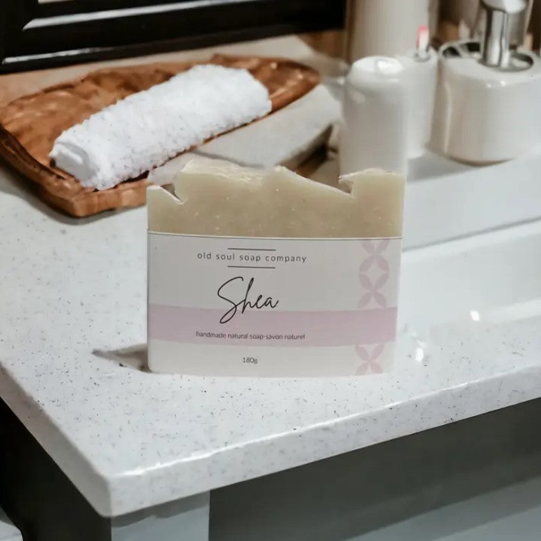 Shea Butter Artisan Soap showing textured surface and embossed logo detail, captured from a slightly angled overhead