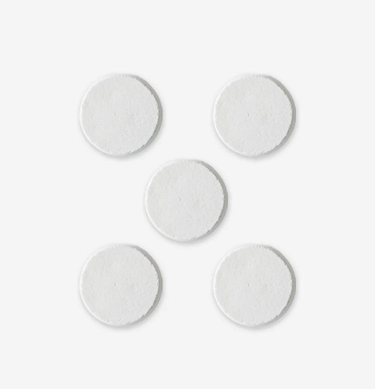 Close-up of the textured surface of Nature Bee Shower Steamers highlighting earthy, organic ingredients with visible