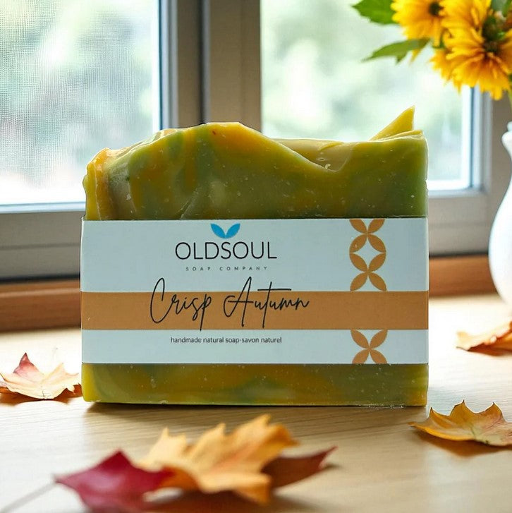 Close-up of four autumn-themed soap bars with textured, leaf-embossed surfaces and warm orange, brown, and cream colors