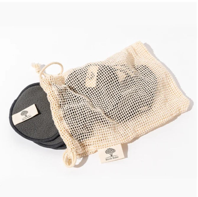 Close-up of reusable bamboo charcoal facial rounds stacked, highlighting soft texture and eco-friendly packaging details.