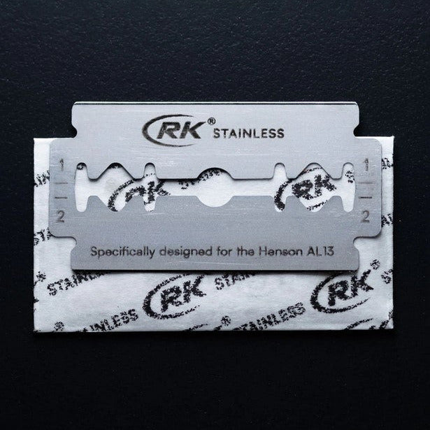 Close-up of the Henson Razor Blades 100 Pack with sharpened stainless steel edges and textured silver wrapping detail