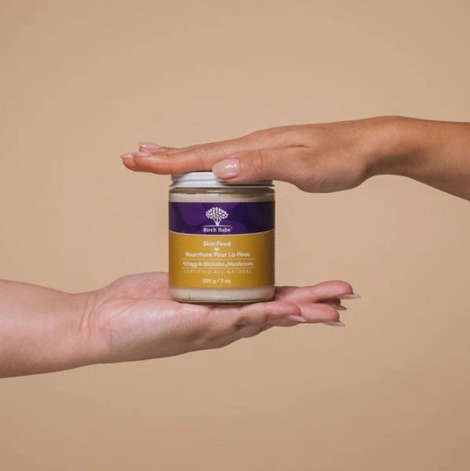 Close-up of Skin Food body lotion's textured, nutrient-rich organic ingredients visible inside a clear jar, emphasizing