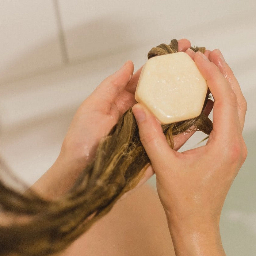Woman using Smooth Operator Shampoo Bar by The Eco Alchemist in shower, moisturizing shampoo bar for thick, curly and frizzy hair made in Canada.